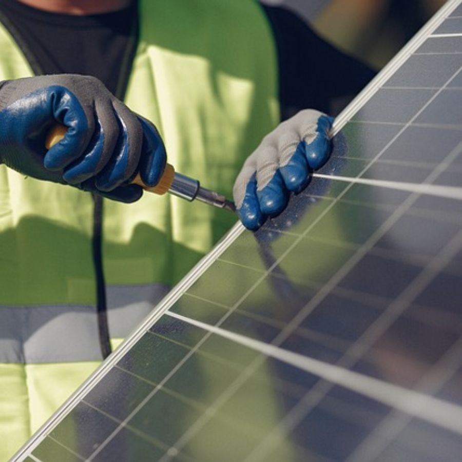 a man fixing a solar panel at an angle