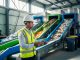 ESH professional inspecting a modern waste-sorting facility with separated waste streams on conveyor systems, symbolizing waste reduction and material recovery in 2026.